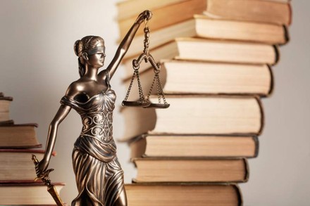 Justitia Figur vor Büchern