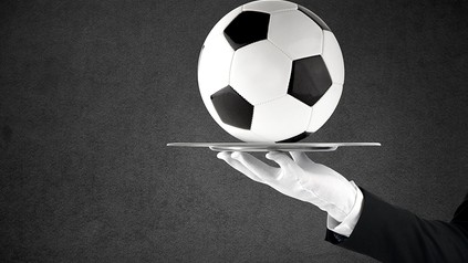 Ein kellner serviert einen Fußball auf einem Tablett