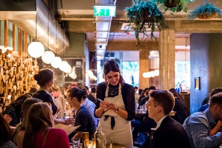 Kellnerin bedient Mann in Restaurant