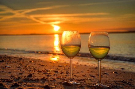 Wein in Glas am Strand im Abendrot