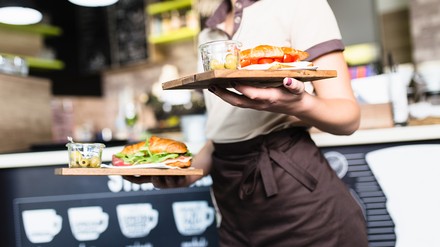 Servicekraft trägt zwei Tablets