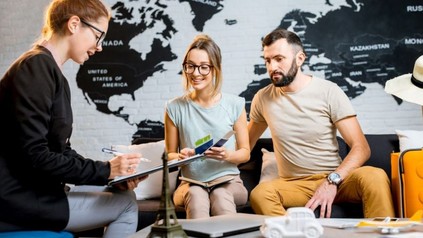 Man und Frau lassen sich im Reisebüro beraten