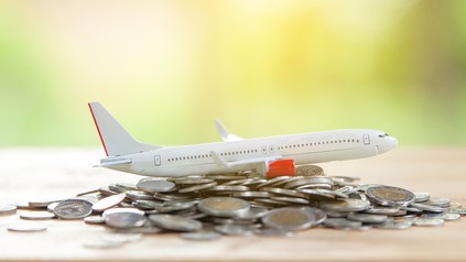 Ein Modell eines Flugzeugs und ein Stapel Geldmünzen