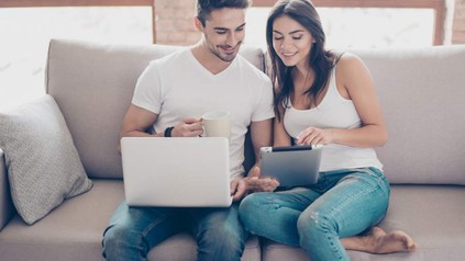 Paar auf Sofa sieht in Tablet