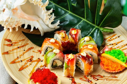 Ein paar bunti Sushis auf einem Bambusteller