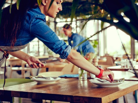 Kellnerin deckt Tisch