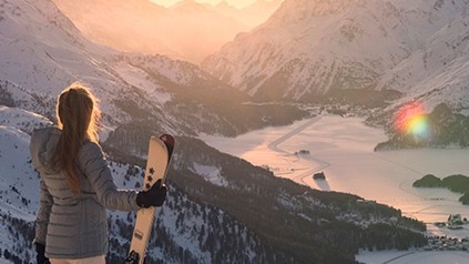 Snowboarderin blickt auf St. Moritz-See bei Sonnenaufgang