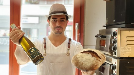 Hausgebackenes Sauerteigbrot und erlesene Weine aus deutschem Anbau – Sommelier Serhat Aktas hat mit seinem Gastronomiekonzept den Nerv der Zeit getroffen. (Foto: © Serhat Aktas)
Serhat Aktas mit Brot und Wein