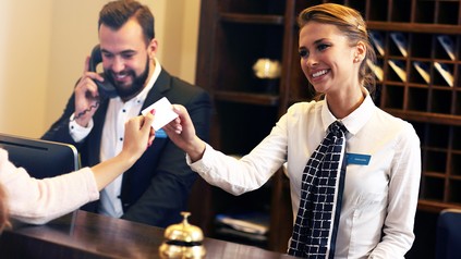 Rezeptionistin überreicht Zugangskarte