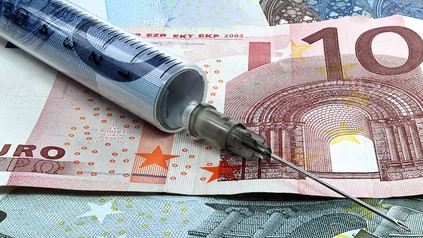 Eine Spritze auf einem Geldschein