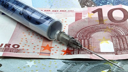 Eine Spritze auf einem Geldschein