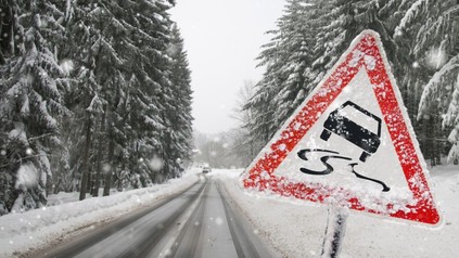 Warnschild auf Schneefahrbahn