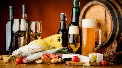 Diverse Lebensmittel mit Bier und Wein auf Tisch