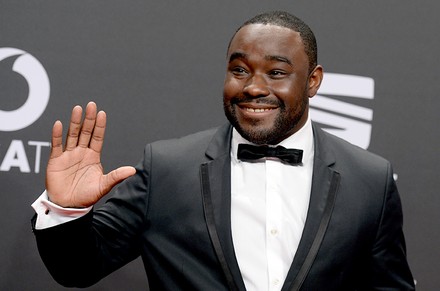 Spitzenkoch Nelson Müller im Anzug winkt einem Publikum zu