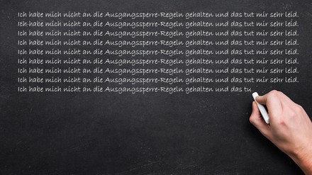 Männliche Hand schreibt mit Kreide an die Tafel