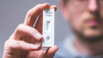 Mann mit Corona-Test in der Hand