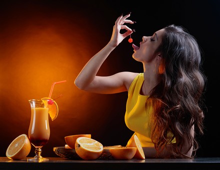 Frau isst Cocktailkirsche