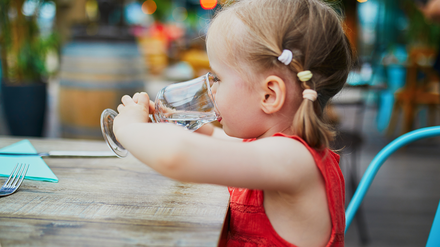 Im Café Kaffeebeere sollen Kinder unter 10 Jahren ab sofort den Innenraum meiden. (Foto: © Ekaterina Pokrovsky/stock.adobe.com)
Kind trinkt aus Glas
