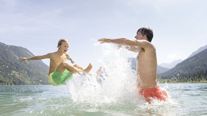 Vater und Sohn spielen im Weissensee in Kärnten