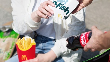 Mann reicht Frau mehrere McDonald's-Produkte