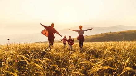 Familie läuft über eine Wiese