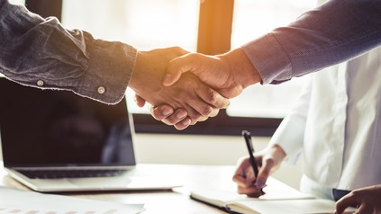 Zwei Männer schließen einen Vertrag und geben sich die Hand