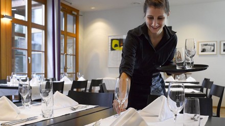 Kellnerin beim Tischdecken